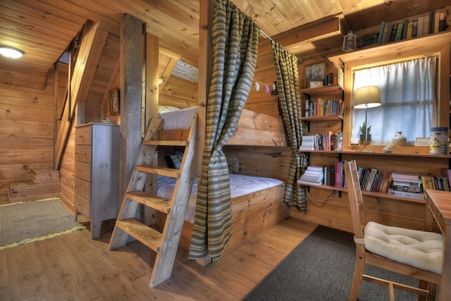 stairway with wooden ceiling, wood-type flooring, and wooden walls