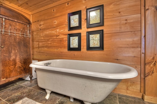 bathroom with wood ceiling, wood walls, and a tub