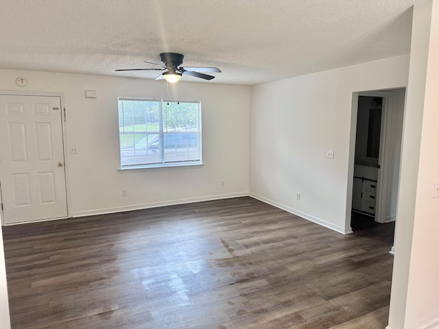 spare room with baseboards, a textured ceiling, dark wood finished floors, and a ceiling fan