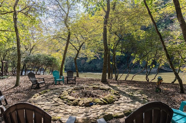 view of home's community featuring a water view and an outdoor fire pit