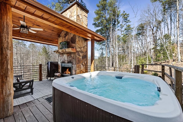 87 Lonesome Dove Path, Blue Ridge, GA 30513 - wooden terrace with an outdoor stone fireplace, a hot tub, ceiling fan, and view of wooded area