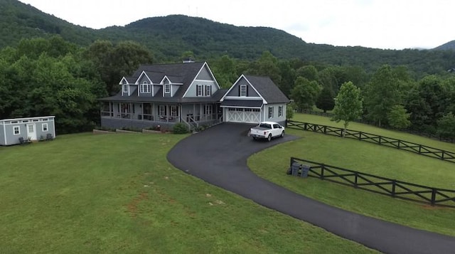 view of front of property with a front yard, a mountain view, and a garage