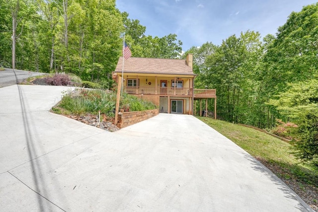 view of front of house with a chimney and driveway