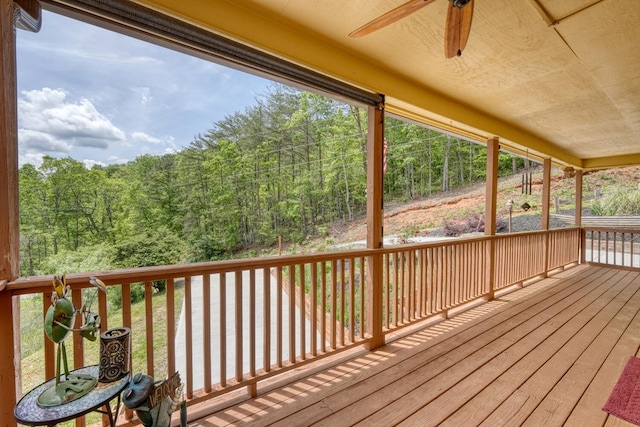 deck with ceiling fan and a wooded view