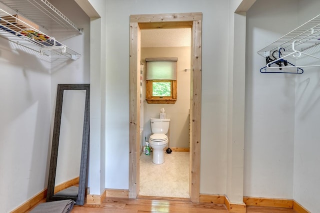 walk in closet with wood finished floors