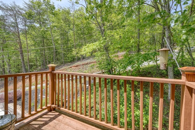 wooden terrace featuring a view of trees