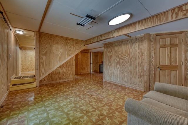 finished below grade area with wooden walls, baseboards, and light flooring