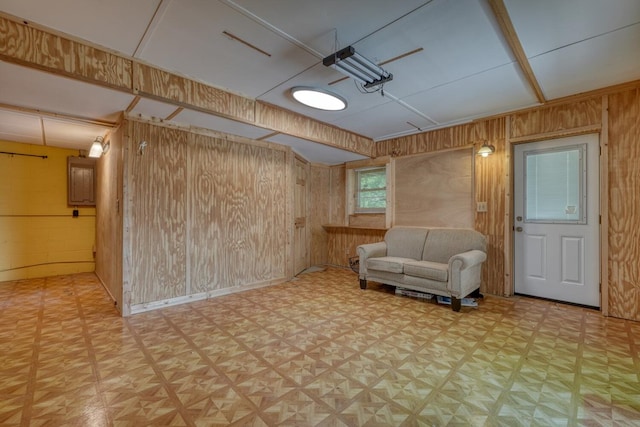 basement featuring wooden walls and light floors