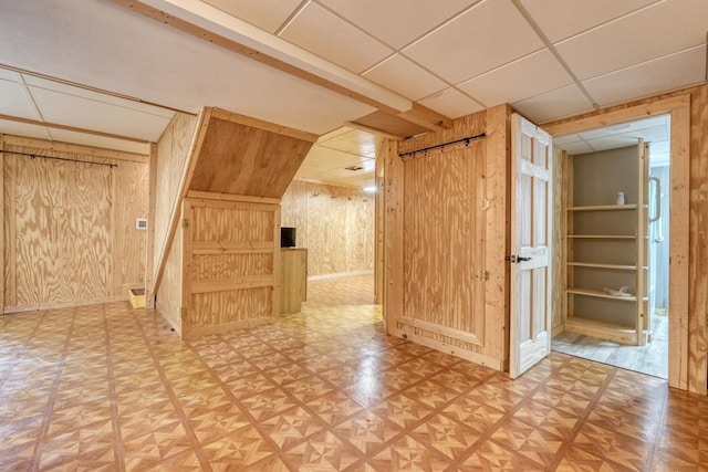 additional living space featuring wood walls and baseboards