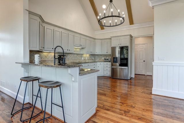 1492 Mcelroy Mountain Dr, Jasper, GA 30143 - kitchen with stainless steel fridge with ice dispenser, a peninsula, dark stone countertops, tasteful backsplash, and a breakfast bar