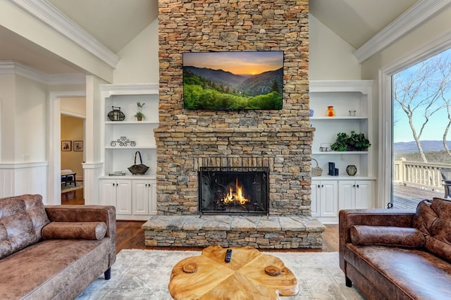 1492 Mcelroy Mountain Dr, Jasper, GA 30143 - living room featuring vaulted ceiling, wood finished floors, built in shelves, a fireplace, and ornamental molding