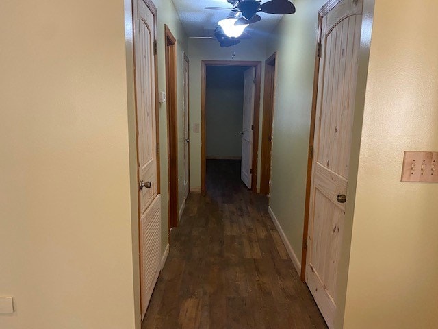 hallway with baseboards and wood finished floors