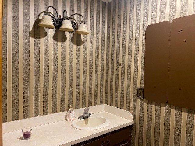 bathroom featuring wallpapered walls and vanity