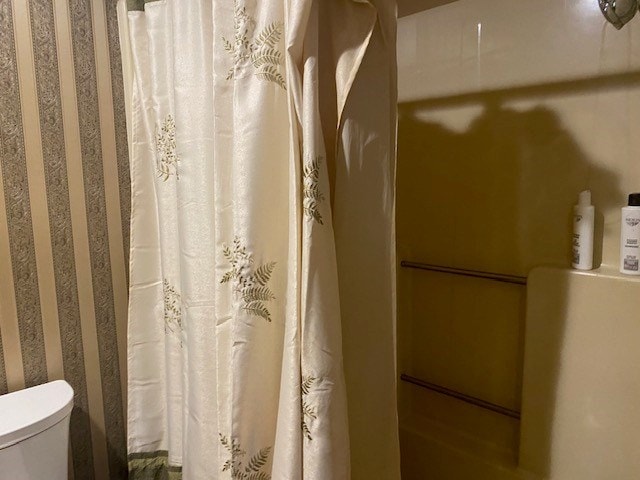 full bath with toilet and a shower with curtain