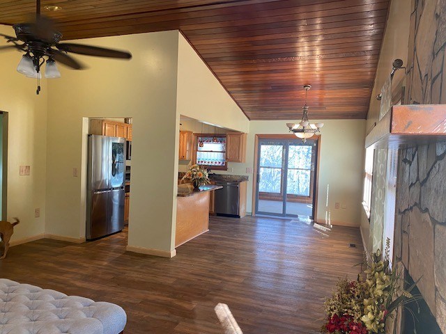 living area featuring high vaulted ceiling, baseboards, dark wood-type flooring, ceiling fan, and a chandelier