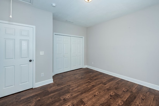 410 N Sharp Mountain Church Ln, Ball Ground, GA 30107 - unfurnished bedroom featuring baseboards, dark wood-style flooring, and a closet