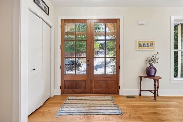 doorway with light wood-type flooring, plenty of natural light, and french doors