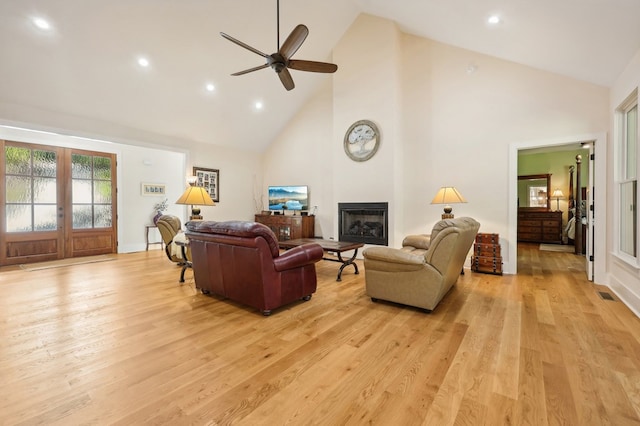 living room featuring ceiling fan, light hardwood / wood-style flooring, and high vaulted ceiling