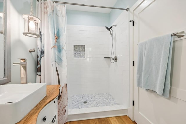 bathroom featuring wood-type flooring, vanity, and curtained shower