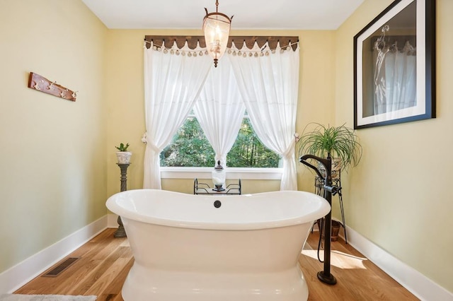 bathroom with hardwood / wood-style flooring and a bathtub