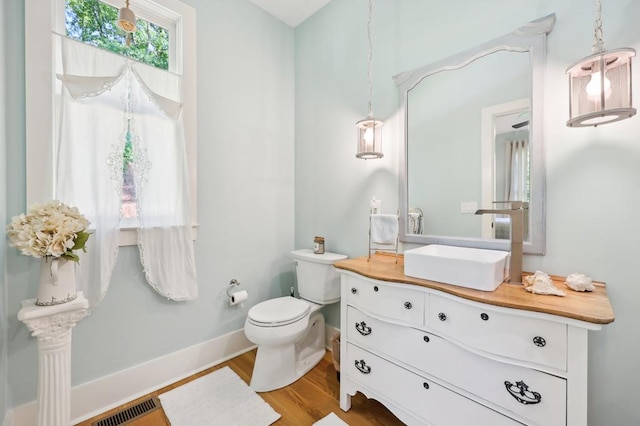 bathroom featuring wood-type flooring, vanity, and toilet