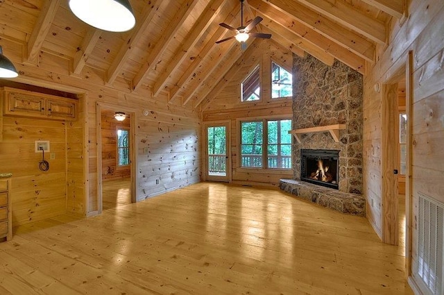 unfurnished living room with light wood-type flooring, a fireplace, a ceiling fan, and visible vents
