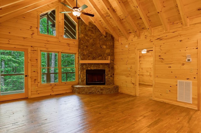 65 Christopher Dr, Ellijay, GA 30540 - unfurnished living room featuring hardwood / wood-style flooring, wood walls, beamed ceiling, high vaulted ceiling, and a stone fireplace