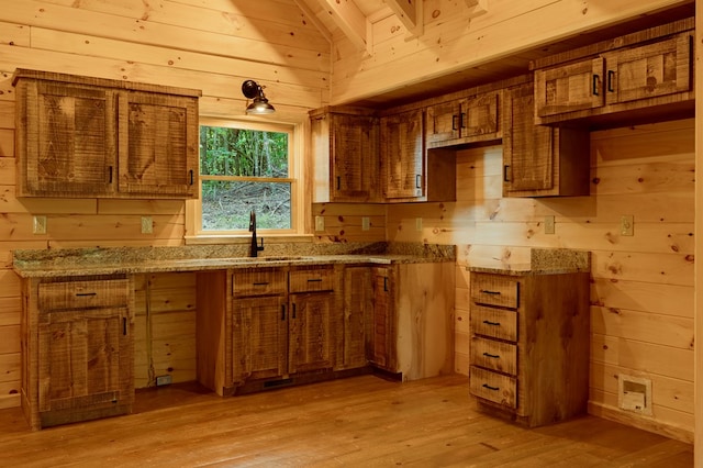 65 Christopher Dr, Ellijay, GA 30540 - kitchen with brown cabinets, wood walls, light wood finished floors, light stone counters, and vaulted ceiling