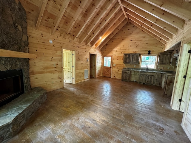 65 Christopher Dr, Ellijay, GA 30540 - unfurnished living room with wood walls, dark wood-style flooring, a fireplace, beam ceiling, and high vaulted ceiling