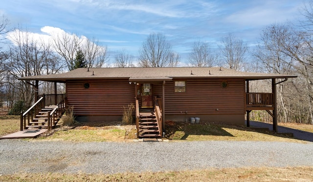view of front facade with faux log siding and a shingled roof