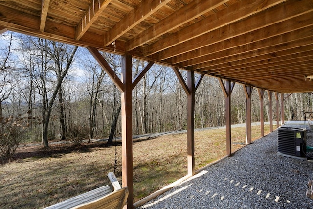view of patio / terrace featuring cooling unit and a forest view