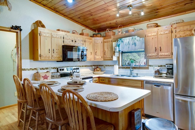 kitchen featuring wood ceiling, light countertops, decorative backsplash, stainless steel appliances, and a sink