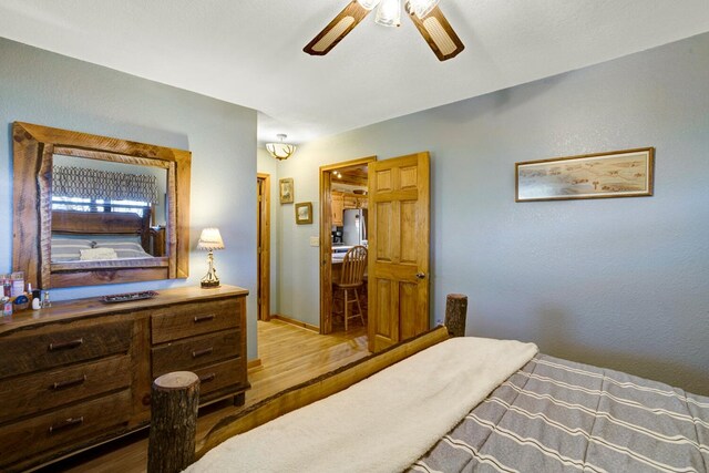 bedroom with baseboards, a ceiling fan, and wood finished floors