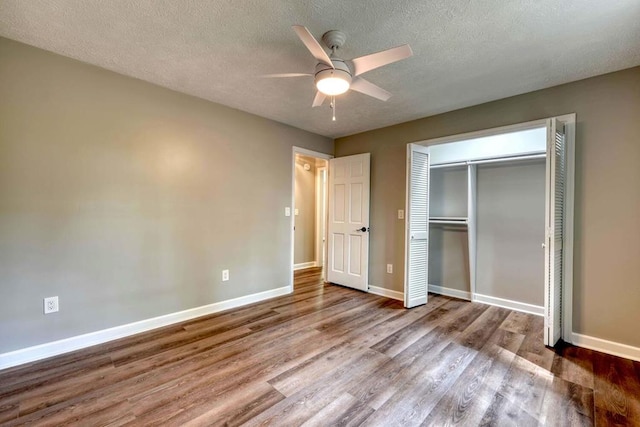 unfurnished bedroom featuring ceiling fan, wood-type flooring, a closet, and a textured ceiling