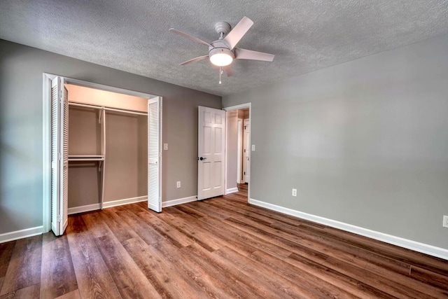 unfurnished bedroom with hardwood / wood-style flooring, ceiling fan, a closet, and a textured ceiling