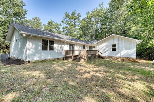 rear view of property featuring a wooden deck, central AC, and a lawn