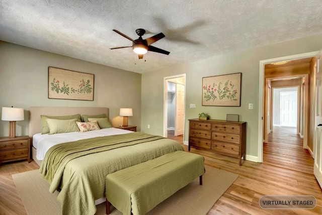 bedroom with a textured ceiling, ceiling fan, and light hardwood / wood-style flooring