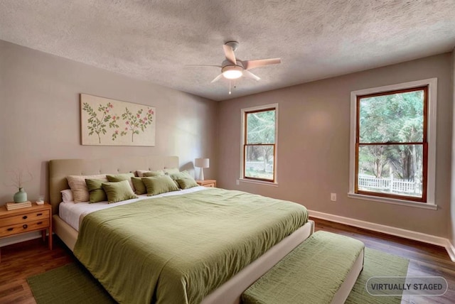 bedroom with a textured ceiling, dark wood-type flooring, and ceiling fan