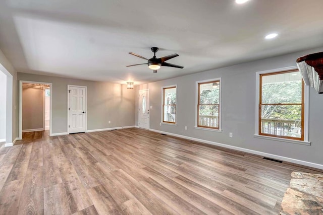 unfurnished room with plenty of natural light, light hardwood / wood-style floors, and ceiling fan