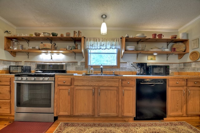 kitchen featuring dishwasher, sink, light wood-type flooring, decorative light fixtures, and stainless steel range with gas stovetop