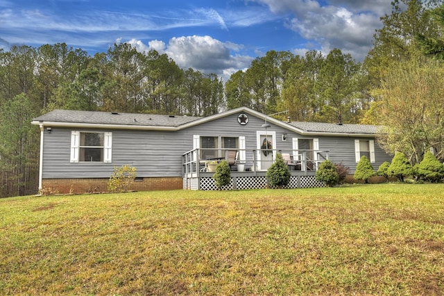 rear view of house featuring a lawn and a deck