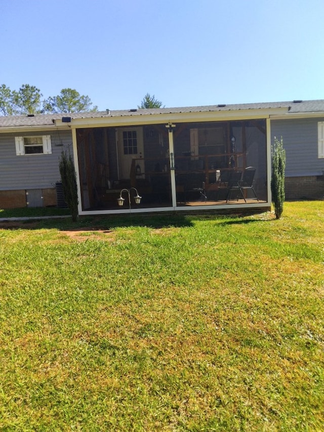 back of property featuring a sunroom and a yard