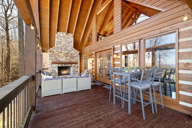 interior space with vaulted ceiling with beams, wood ceiling, and an outdoor stone fireplace