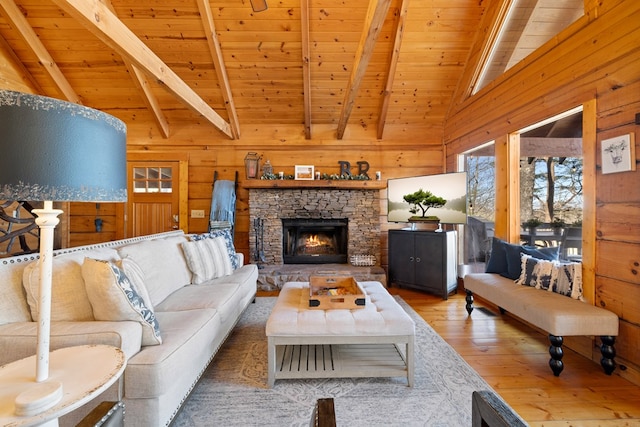 living room featuring wooden walls, a fireplace, vaulted ceiling with beams, hardwood / wood-style flooring, and wood ceiling