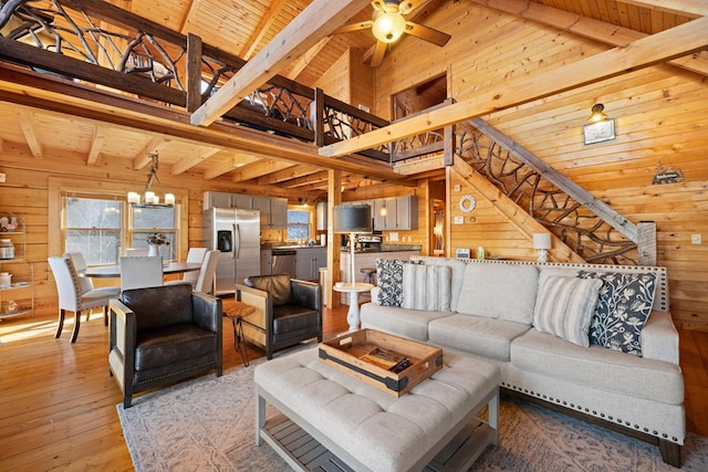 living room with beamed ceiling, high vaulted ceiling, and wood walls