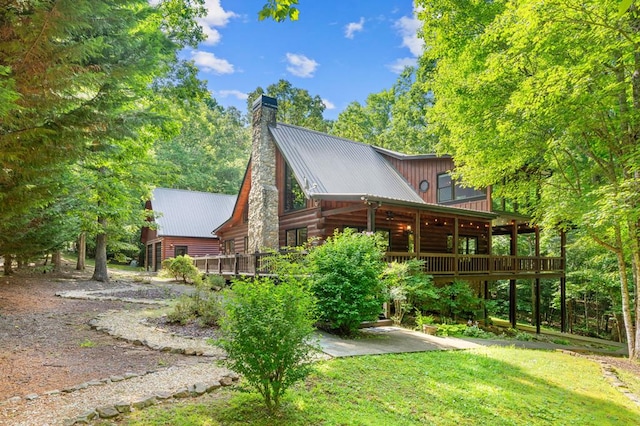 view of side of property featuring a yard and a deck