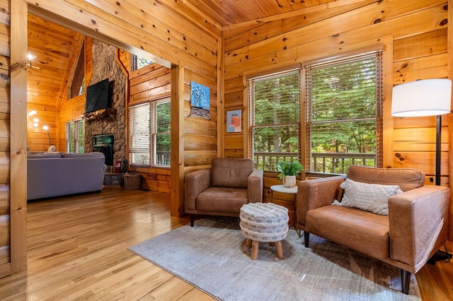 sitting room with wood ceiling, a healthy amount of sunlight, high vaulted ceiling, and light hardwood / wood-style flooring