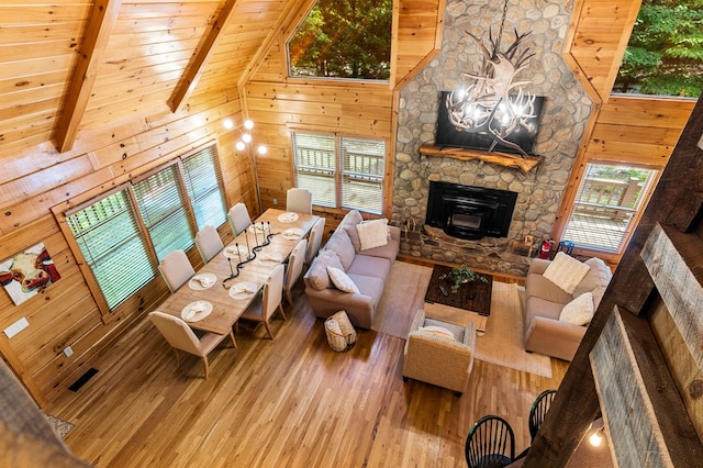 living room with hardwood / wood-style floors, high vaulted ceiling, wooden ceiling, beamed ceiling, and wood walls