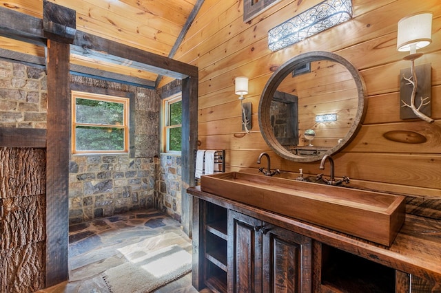 bathroom featuring vanity, vaulted ceiling, wooden ceiling, and wooden walls