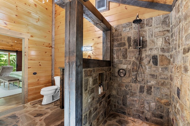 bathroom with toilet, a shower, and wood walls